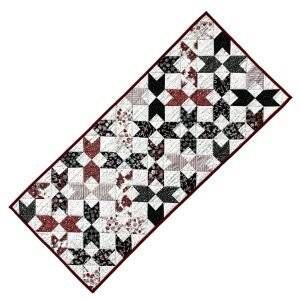 Christmas themed quilted table runner featuring reds and greens