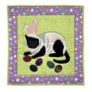 Wall quilt featuring a cat in a bunny costume with Easter eggs