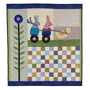 quilted wall art featuring a flower, bunnies, and a chick with spring colors