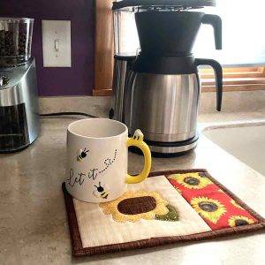 Sunflower mug rug with coffee cup and coffee pot in the kitchen