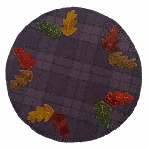 Hand-dyed wool mat featuring colorful autumn leaves in yellow, red, orange, and brown on a purple background.