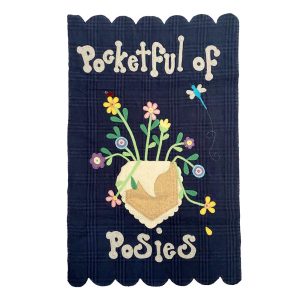 Cotton wall quilt with a whimsical pocket overflowing with colorful flowers in yellow, pink, purple, and blue. The text "Pocketful of Posies" is at the top and bottom, with a dragonfly detail and scalloped edges.