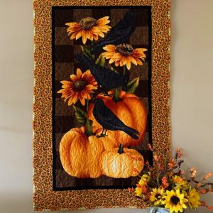 "Pumpkins & Crows" Wall Quilt 31 x 50, yellow and orange sunflowers with green leaves with orange and yellow pumpkins, black birds sitting on pumpkins and sunflowers.
