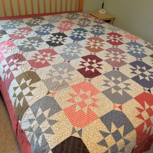 "Disappearing Stars" Bed Quilt 82 x 92, pinks, blues, browns, greens, reds, tan fabrics sewn together like stars