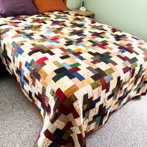 Floating Pinwheels Quilt multiple colored scraps of fabric quilted together in a pinwheel design