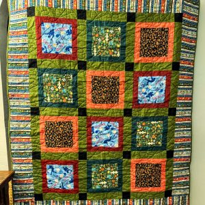 "Sports for All" Couch Quilt 55 X 64 orange, green brown and blues with footballs, basketballs, baseballs, soccer balls, and tennis balls